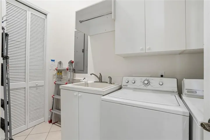 Laundry room with full sized washer and dryer, plus a laundry tub