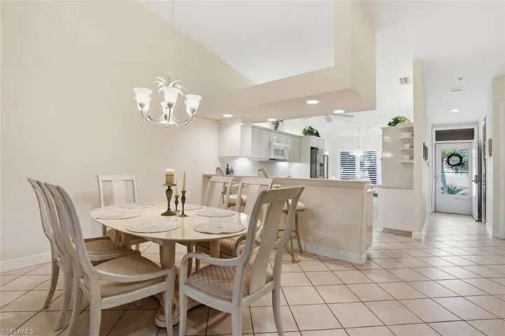 Formal dining area featuring a vaulted ceiling and a decorative chandelier