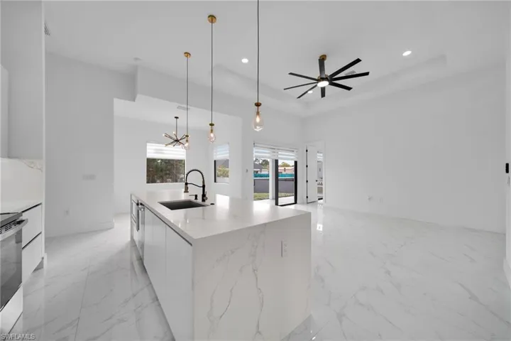 Kitchen featuring light marble finish floors, modern cabinets, white cabinetry, and recessed lighting