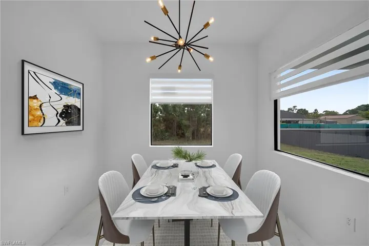 Dining room with marble look tile flooring, plenty of natural light, and a chandelier