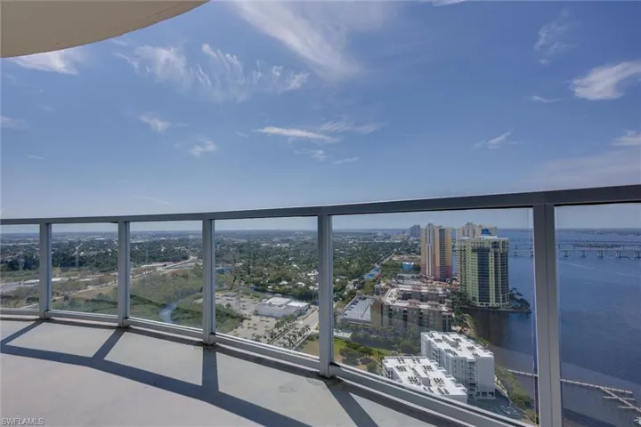 Balcony featuring a water view and a city view