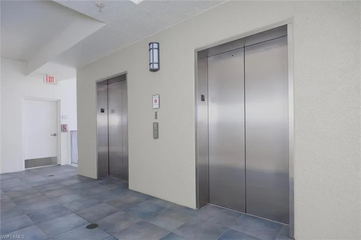 Hall featuring elevator and a textured wall