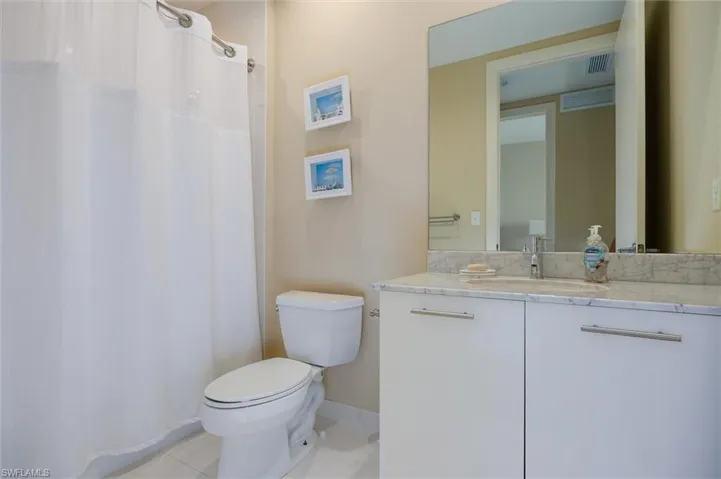 Bathroom with a shower with shower curtain, vanity, and light tile patterned floors