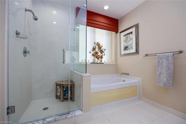 Full bathroom featuring a bath, a stall shower, and light tile patterned flooring