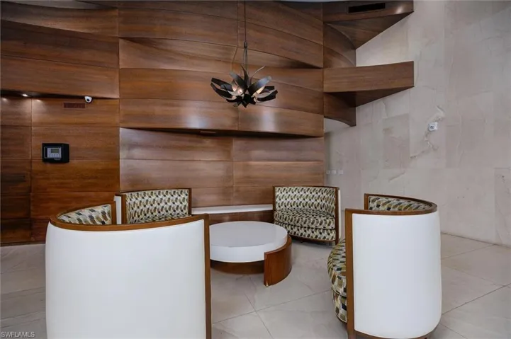 Full bath featuring a soaking tub, tile walls, and hanging lights