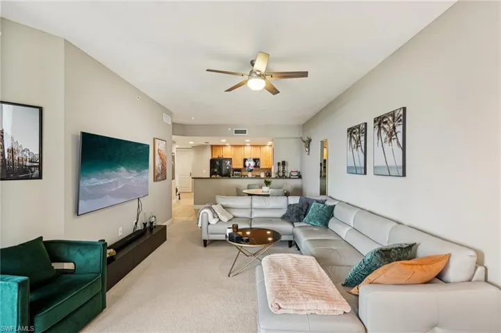 Living area with light colored carpet and ceiling fan