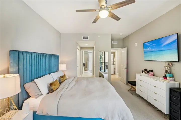 Bedroom with light colored carpet and a ceiling fan