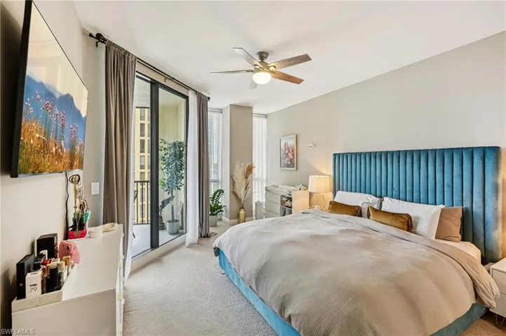 Carpeted bedroom with floor to ceiling windows, access to exterior, and a ceiling fan