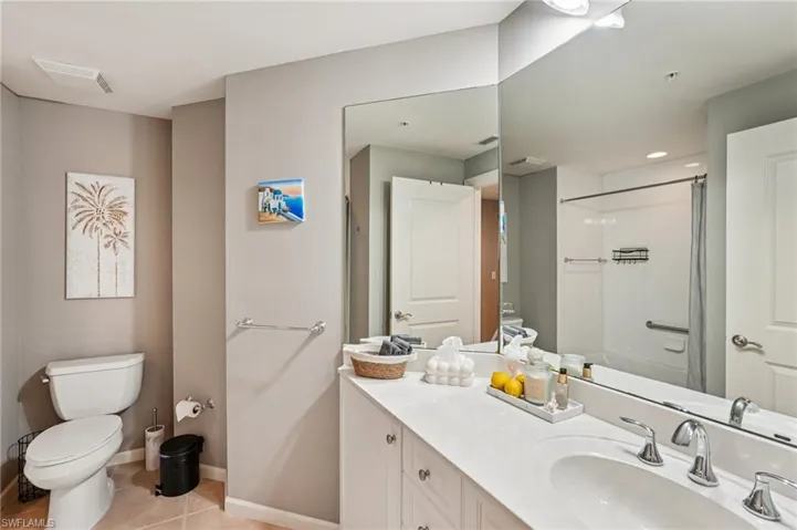 Full bathroom with vanity, light tile patterned floors, and a shower