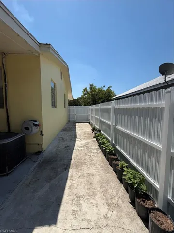 View of side of home featuring a fenced backyard, stucco siding, and a patio area