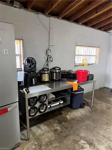 Detailed view of refrigerator and unfinished concrete floors