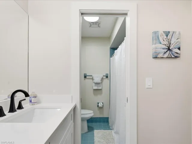Full bathroom with vanity, a shower with curtain, and tile patterned flooring