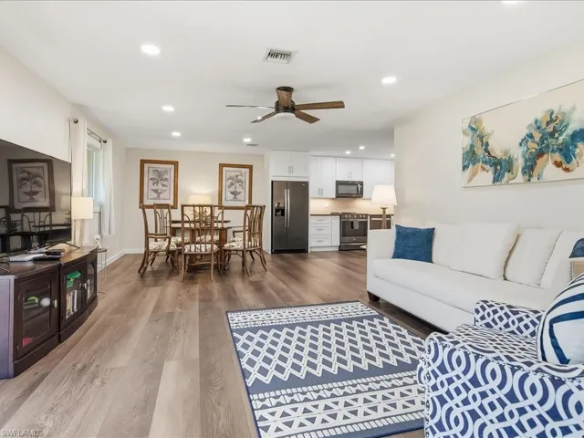 Living room with recessed lighting, light wood-style flooring, and a ceiling fan