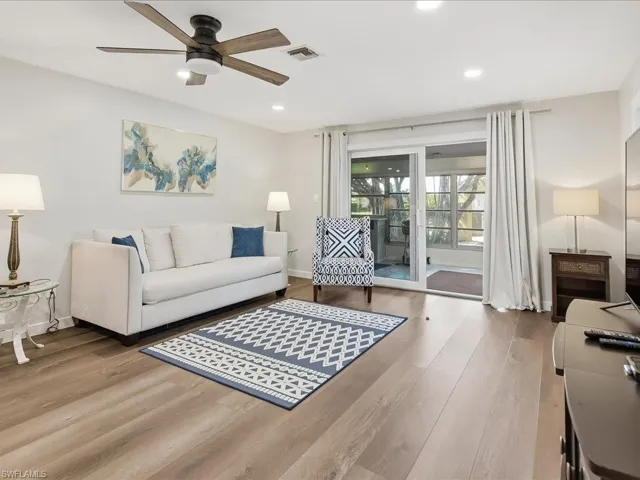 Living area with light wood-style flooring, a ceiling fan, and recessed lighting
