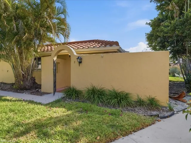 View of side of property featuring stucco siding, a yard, and a tile roof
