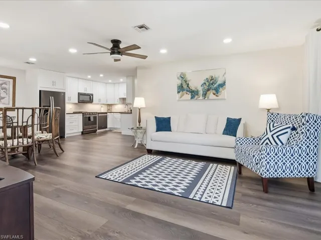 Living area with dark wood finished floors, ceiling fan, and recessed lighting