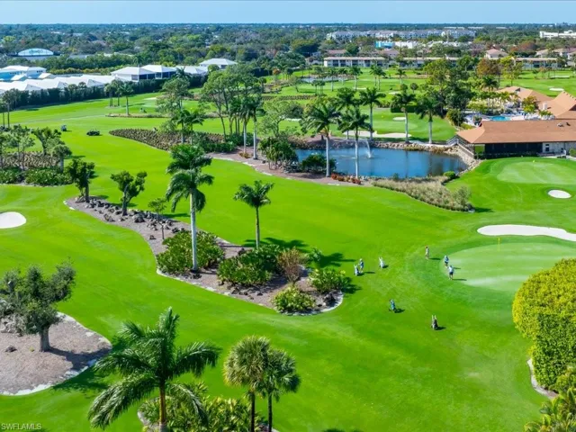 Aerial view of residential area featuring a nearby body of water and a golf course