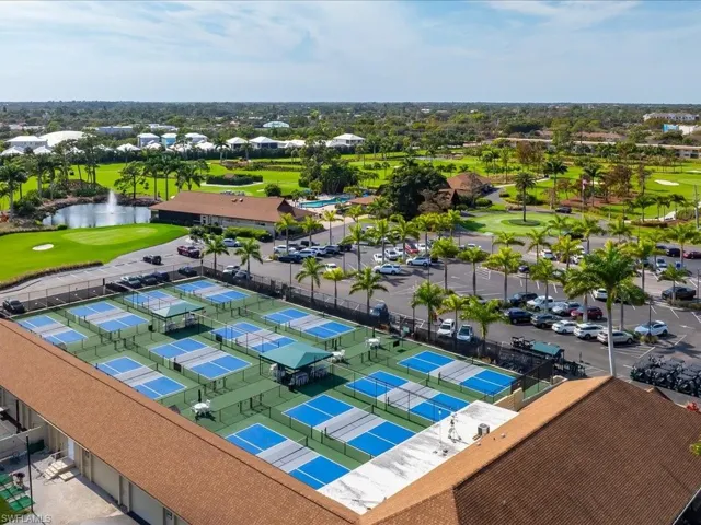 Aerial perspective of suburban area featuring a golf course and a nearby body of water