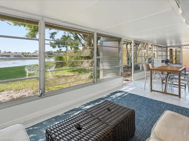 Sunroom / solarium with a water view, healthy amount of natural light, and outdoor dining space