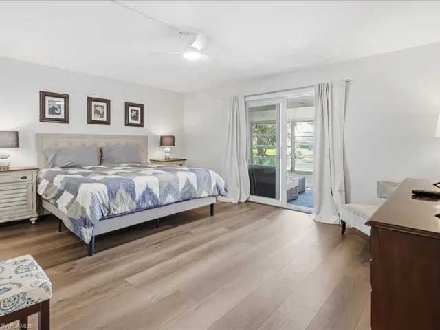 Bedroom with access to outside, ceiling fan, wood finished floors, and an office area