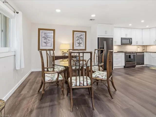 Dining area with dark wood finished floors and recessed lighting