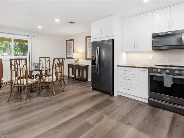 Kitchen featuring stainless steel appliances, white cabinets, recessed lighting, dark stone counters, and tasteful backsplash