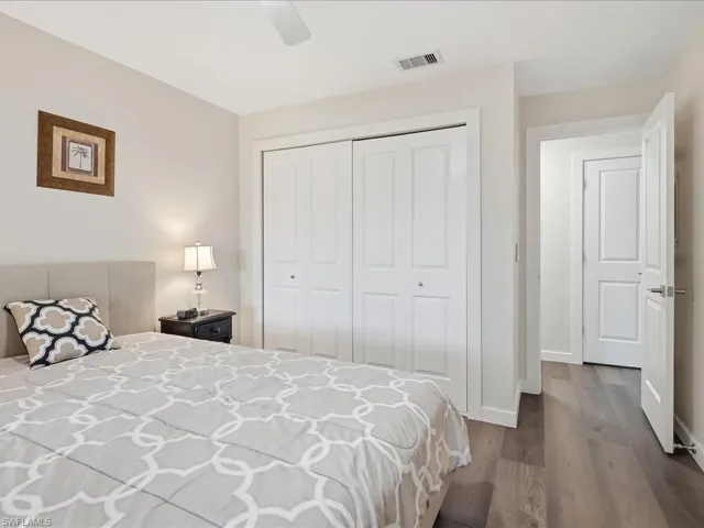 Bedroom with a closet, dark wood finished floors, and a ceiling fan