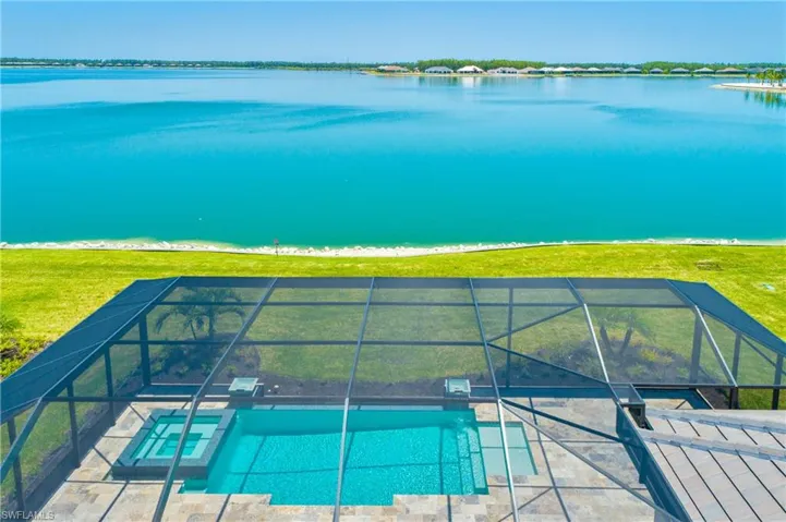 Relaxing pool / spa with glass enclosure and a water view