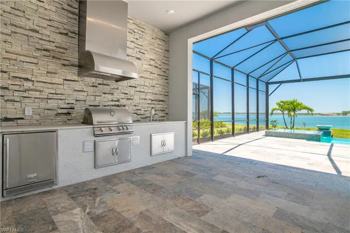 View of patio with a sunroom, a lanai, a water view, and area for grilling