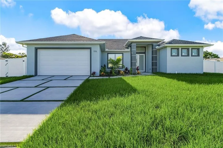 View of front of home with stucco siding, concrete driveway, an attached garage, and roof with shingles