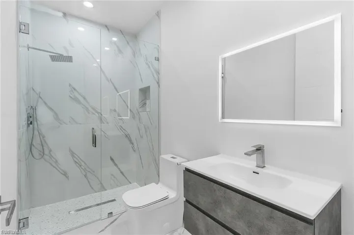 Full bath with vanity and a marble finish shower