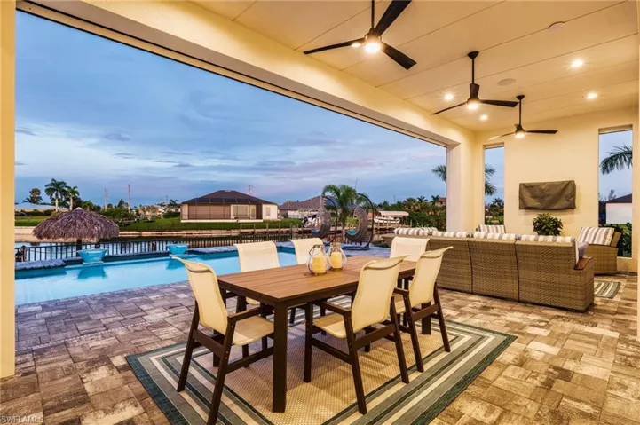 Expansive covered patio featuring patterned paver flooring and recessed lighting