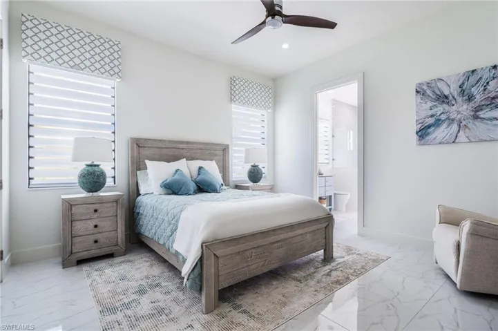 Guest bedroom with white walls and polished tile flooring