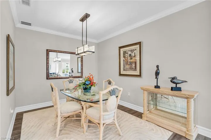Dining room with ornamental molding and hardwood / wood-style floors