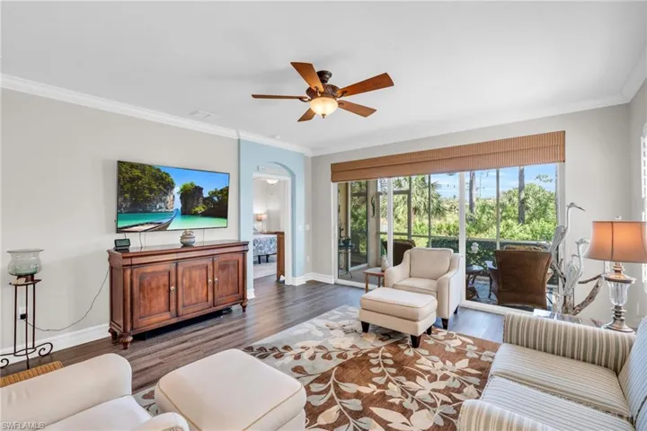 Living room featuring ornamental molding, dark hardwood / wood-style floors, and ceiling fan