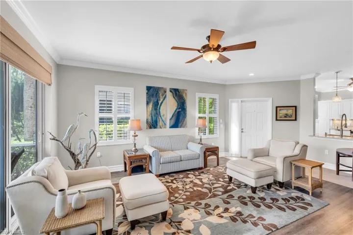 Living room with a healthy amount of sunlight, hardwood / wood-style flooring, and ceiling fan