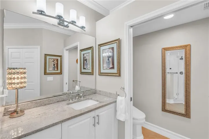 Bathroom with toilet, crown molding, vanity, and tile patterned flooring