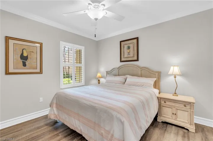 Bedroom featuring dark wood-type flooring, ceiling fan, and ornamental molding