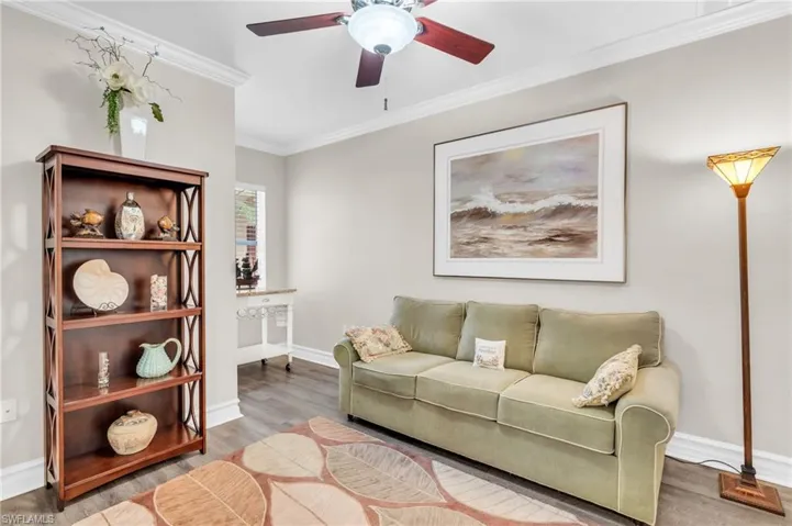 Living room featuring crown molding, hardwood / wood-style flooring, and ceiling fan