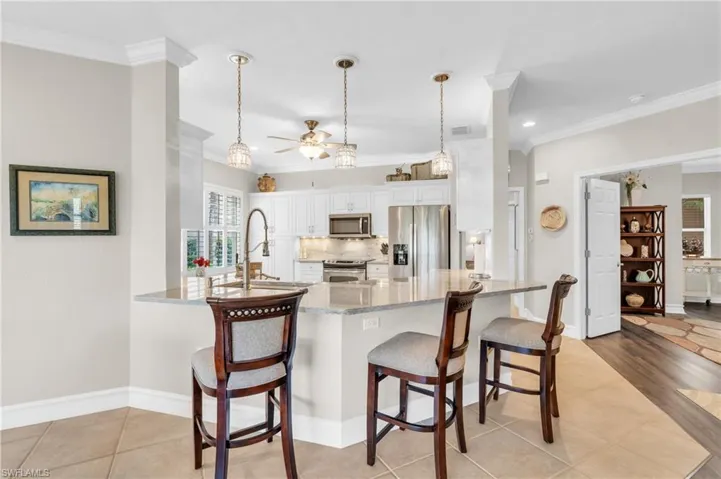 Kitchen with white cabinets, kitchen peninsula, stainless steel appliances, and a healthy amount of sunlight