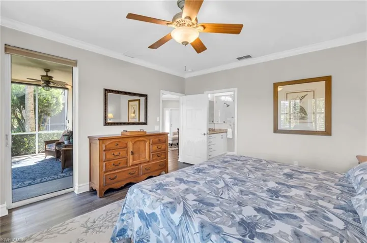 Bedroom with access to exterior, dark hardwood / wood-style floors, ensuite bath, ornamental molding, and ceiling fan