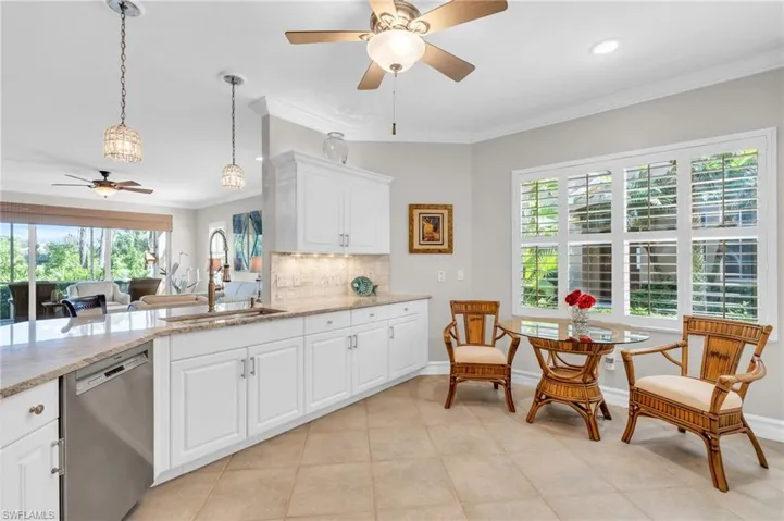 Kitchen with white cabinets, a healthy amount of sunlight, stainless steel dishwasher, and sink