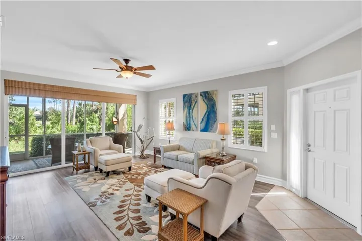 Living room featuring ceiling fan, hardwood / wood-style flooring, and ornamental molding