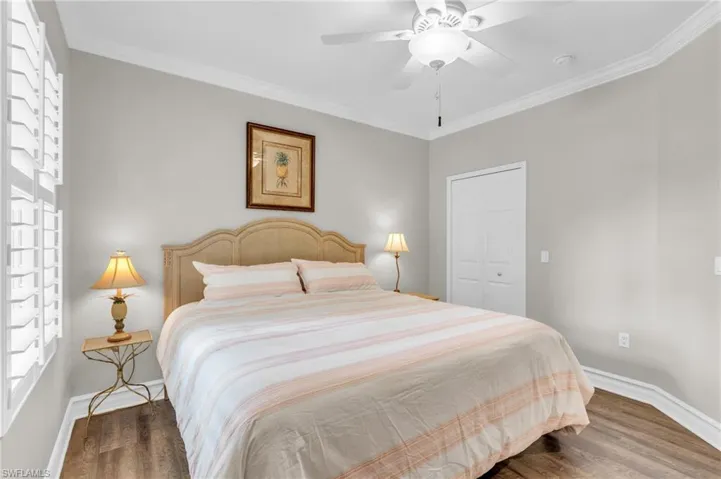 Bedroom featuring dark hardwood / wood-style flooring, ornamental molding, a closet, and ceiling fan