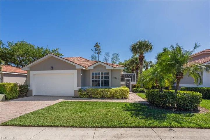 View of front of home with stucco siding, a tiled roof, an attached garage, and decorative driveway