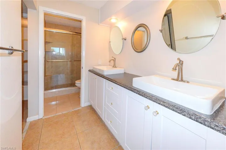 Bathroom with an enclosed shower, dual sinks