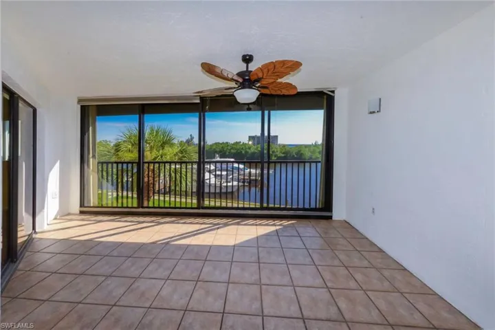 Sunroom with ceiling fan and a water view
