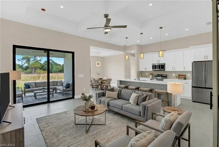 Virtually Staged- Living room with coffered ceiling, a ceiling fan, and hanging lights