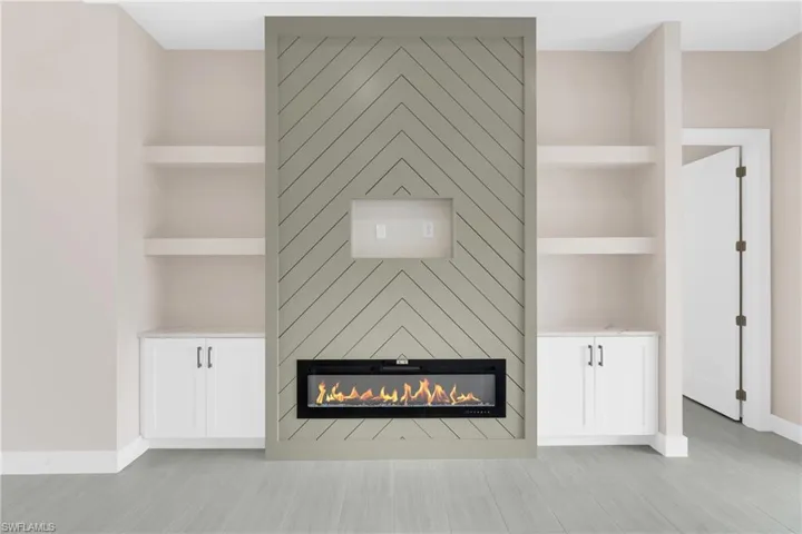 Detailed view of built in shelves and a large fireplace