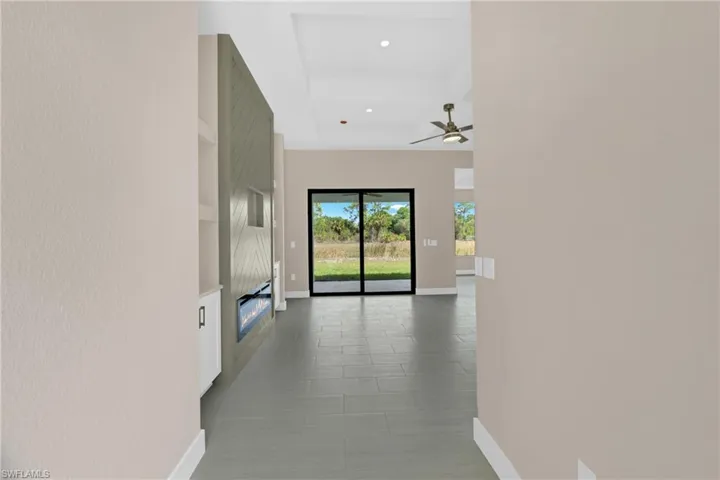 Hallway with recessed lighting and a raised ceiling